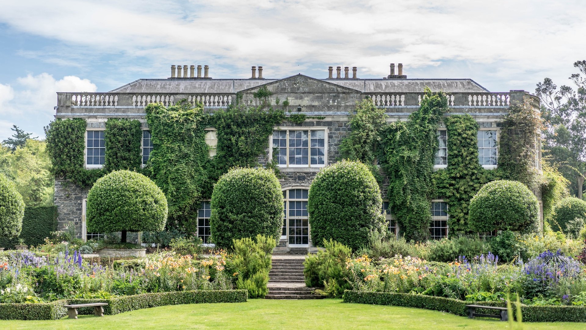 Picture from the back of the house showing the building and sorounding garden