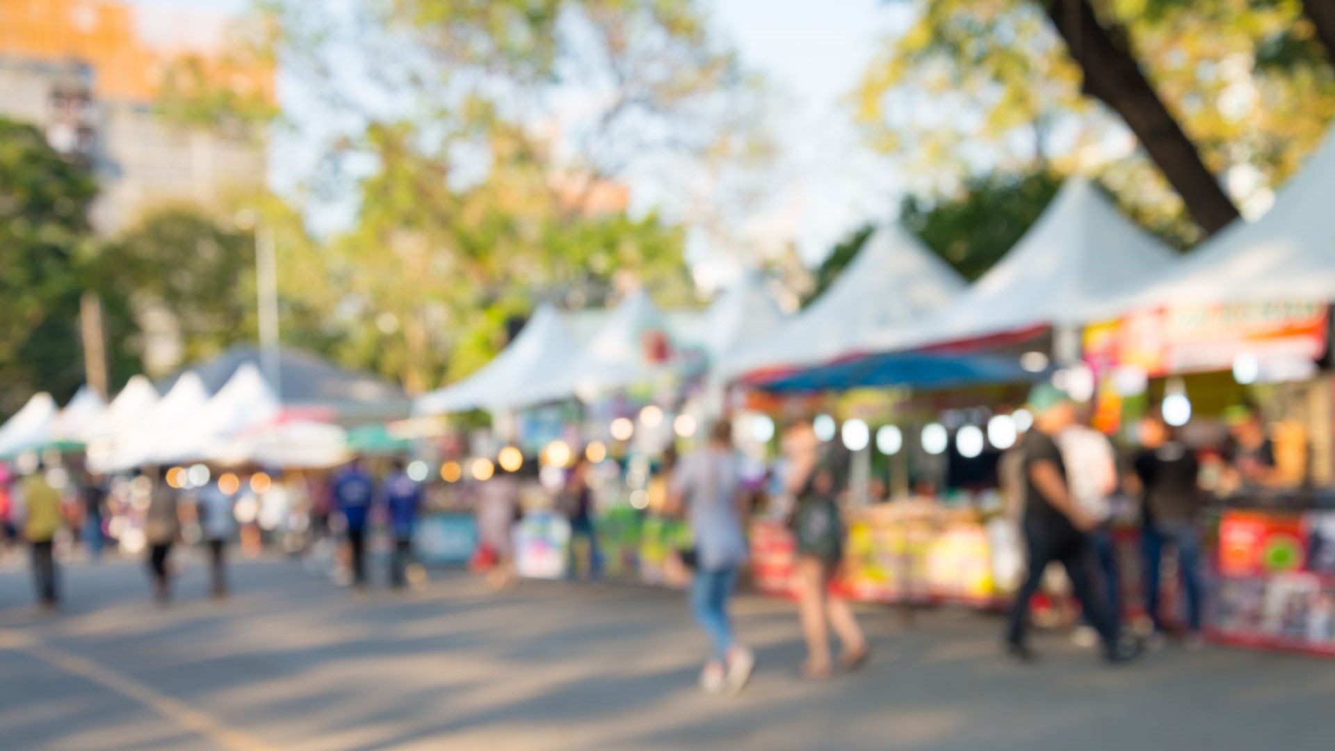 Blurred image of people in day market festival in city park background